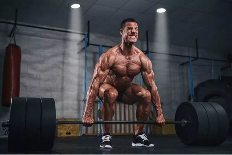 Athletic male performing a controlled barbell squat in a modern gym