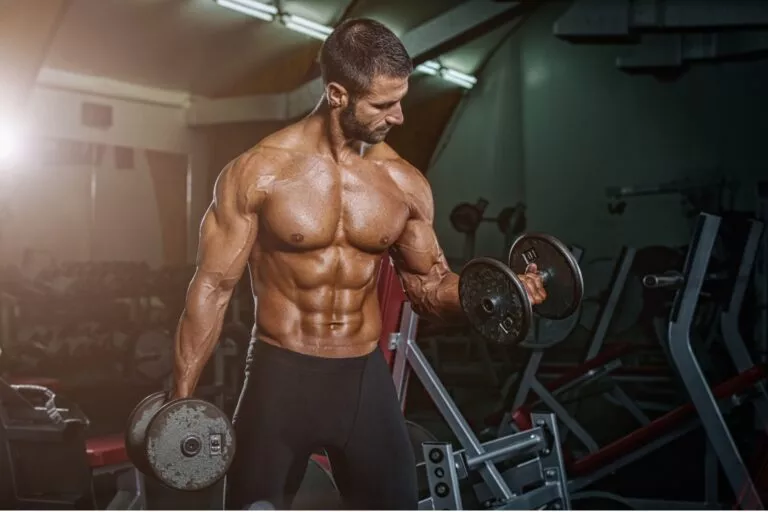Athletic male walking through an industrial style gym after training