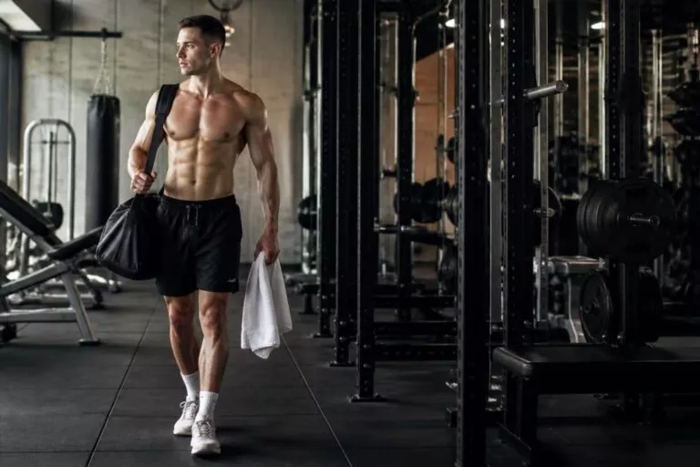 Athletic male walking through an industrial style gym after training