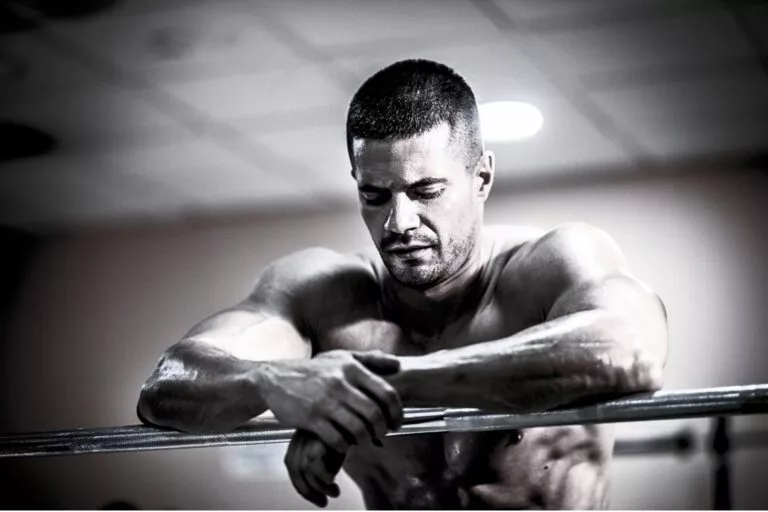 Athletic male recovering after an intense training session in a premium gym